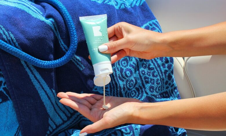 Foto de una persona aplicando crema solar en la playa