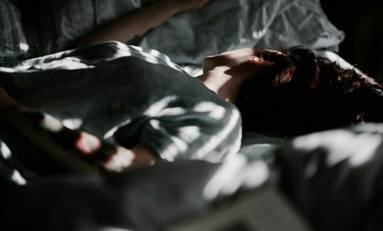 Persona durmiendo tranquilamente en una cama oscura