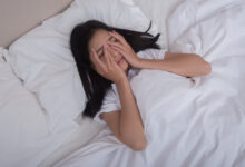 Persona relajada en la cama, con una luz suave y un ambiente tranquilo