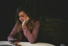 Mujer mirándose al espejo con una expresión de insatisfacción