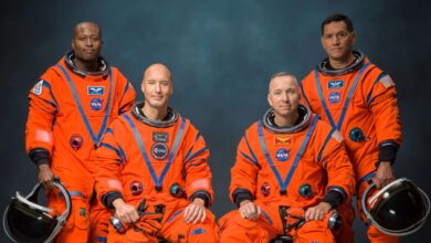 Astronautas de la misión Artemis III posan con el logotipo de la NASA