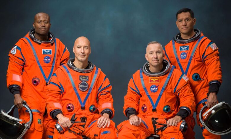 Astronautas de la misión Artemis III posan con el logotipo de la NASA