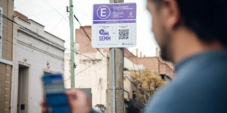 Imagen de un automóvil estacionado en una calle de Córdoba con un constatador cerca
