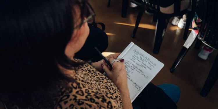 Imagen de una persona en un curso de capacitación laboral, sonriendo y con un certificado en la mano