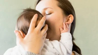 Mujer con su bebé, sonriendo y abrazándolo