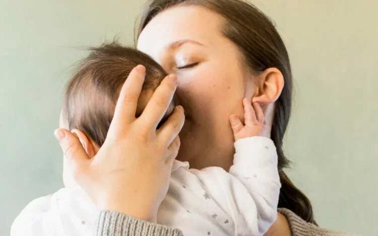 Mujer con su bebé, sonriendo y abrazándolo