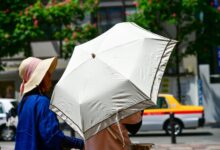 Persona protegiéndose del sol con un paraguas