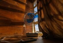 Persona frente a un ventilador con una temperatura alta en el termómetro