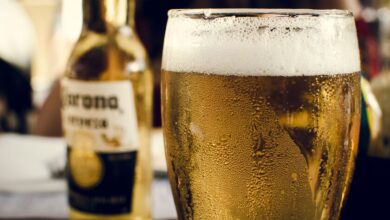 Persona bebiendo cerveza en la playa con un ambiente caluroso