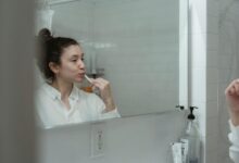 Un hombre se cepilla los dientes en el baño