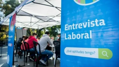 Persona sonriente con un traje y una carpeta en la mano, simbolizando el empleo