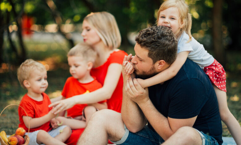 Padres y madres con sus hijos jugando en un parque
