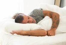 Persona en la cama con la televisión encendida