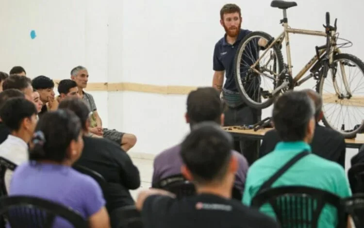 Grupo de personas aprendiendo a reparar bicicletas en una clase en la Universidad Libre del Ambiente
