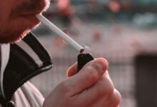 Persona mayor fumando en una terraza, símbolo de la soledad vinculada al tabaco
