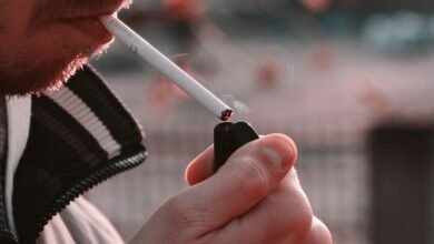 Persona mayor fumando en una terraza, símbolo de la soledad vinculada al tabaco
