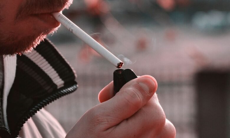 Persona mayor sosteniendo un cigarro, mirada pensativa, simbolizando la relación entre fumar y la soledad