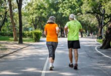 Adulto mayor caminando rápido en una calle arbolada de Córdoba