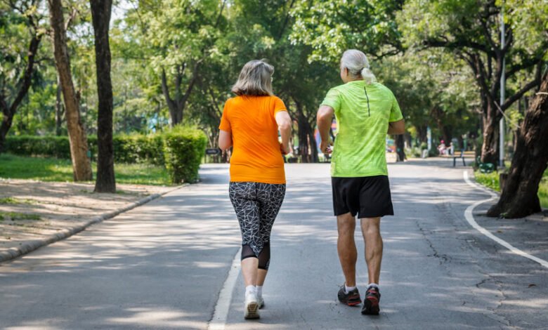 Adulto mayor caminando rápido en una calle arbolada de Córdoba