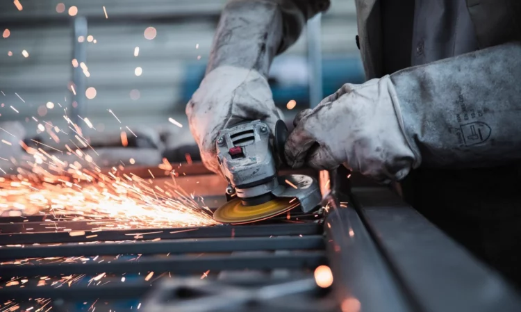 Planta metalúrgica de Córdoba con maquinaria parada y empleados observando la línea de producción