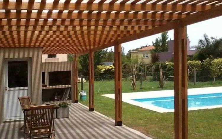 Pérgola de madera con enredaderas que amplía el espacio habitable en un barrio cordobés