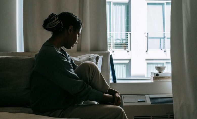 Persona sentada sola en una habitación, simbolizando el impacto de la soledad en la salud mental