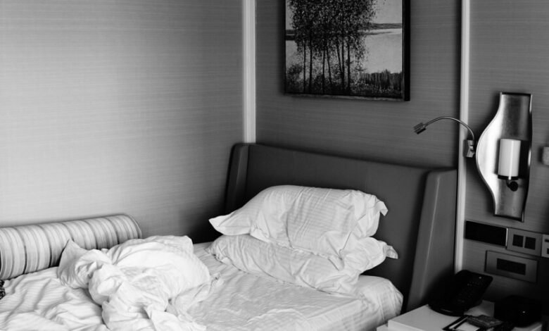 Cama sin hacer con sábanas arrugadas y almohada en una habitación luminosa