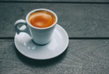 Taza de café sobre mesa con ilustración de bacterias intestinales