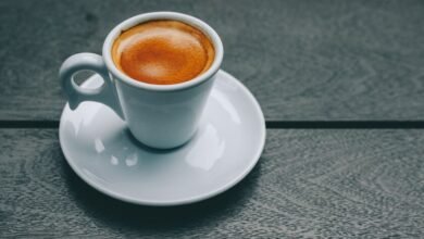 Taza de café sobre mesa con ilustración de bacterias intestinales