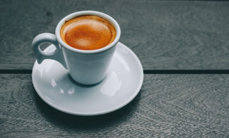 Taza de café sobre mesa con ilustración de bacterias intestinales