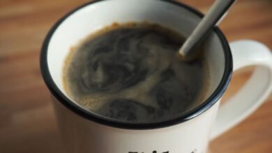 Taza de café humeante sobre una mesa de madera en la mañana