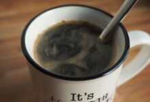 Taza de café humeante sobre una mesa de madera, símbolo de la rutina matutina