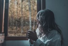 Persona tomando mate mientras escucha la lluvia en una ventana de Córdoba
