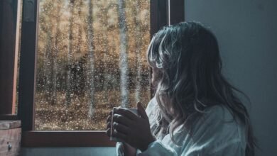 Persona tomando mate mientras escucha la lluvia en una ventana de Córdoba