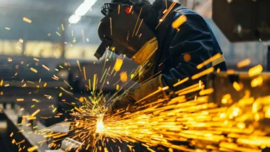 Fábrica metalúrgica en Córdoba con máquinas detenidas y trabajadores inspeccionando la línea de producción