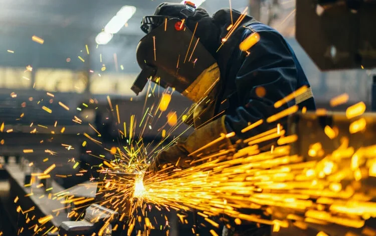 Fábrica metalúrgica en Córdoba con máquinas detenidas y trabajadores inspeccionando la línea de producción